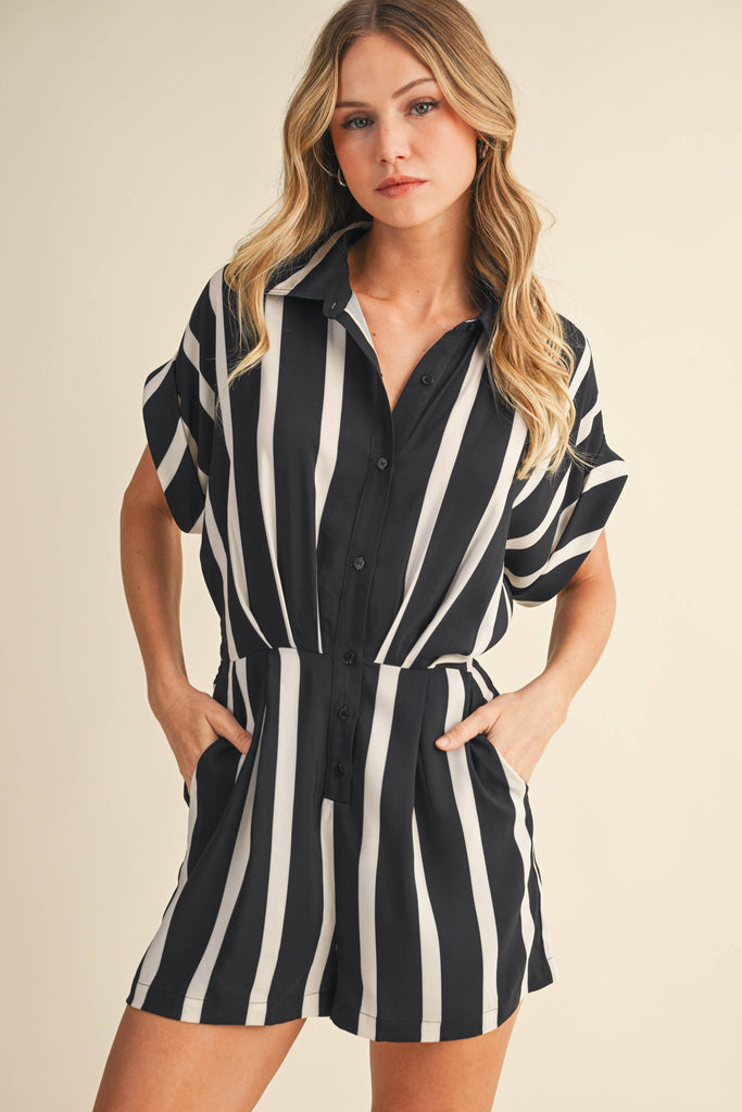 Woman wearing a black and white striped romper against a beige background