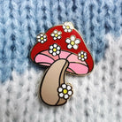 Daisy Mushroom Enamel Pin, featuring a captivating blend of mushroom and daisy design, radiating nature's playful charm.