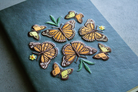 Green notebook with embroidered monarch butterfly design.
