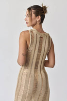 Woman wearing a sleeveless ladder knit midi dress.