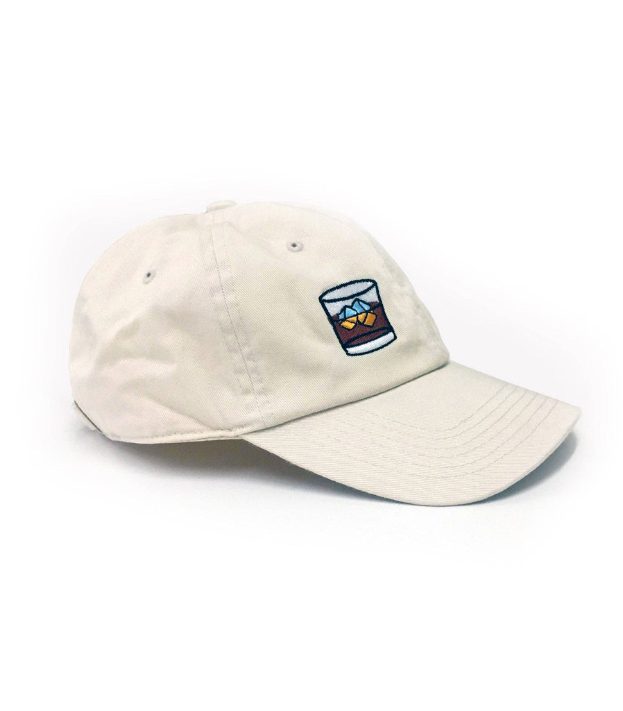 Beige baseball cap with embroidered whiskey glass and cigar design on the front.