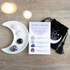 Love Crystal Set featuring a crescent moon trinket dish, rose quartz, clear quartz, amethyst, and rhodonite stones, displayed with a matching information card and a printed drawstring pouch.