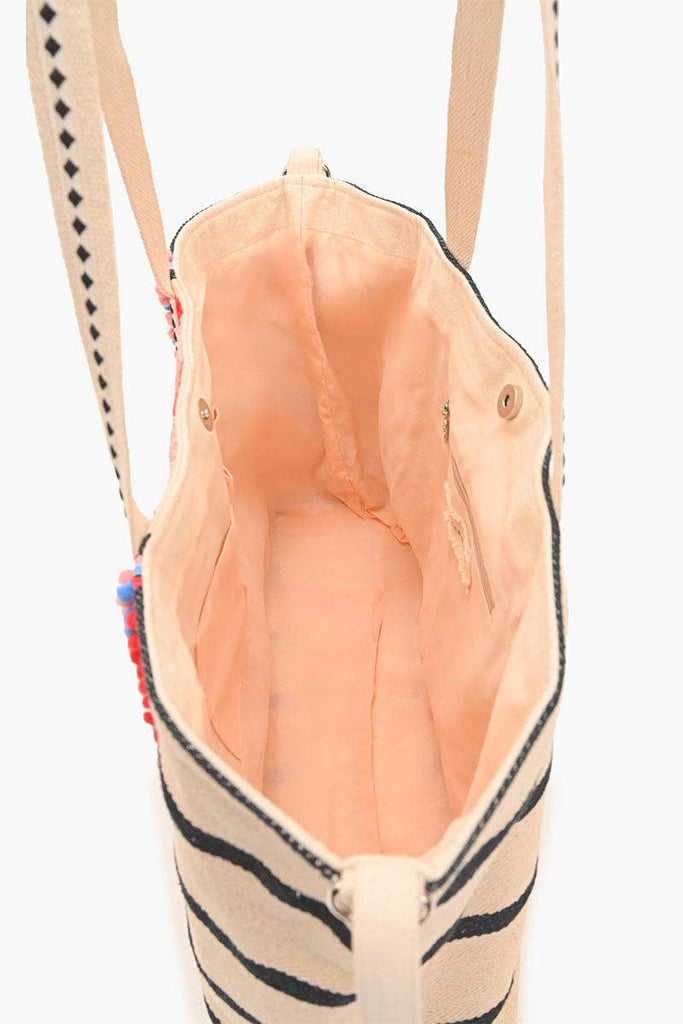 Beaded tote bag with sunset, palm tree, and ocean design, featuring black stripes, colorful pom-pom trim, and long handles.