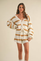 Woman wearing a cream and camel striped knit set with button cardigan and drawstring shorts.
