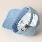 Light-wash denim baseball cap with embroidered black and white French Bulldog design.