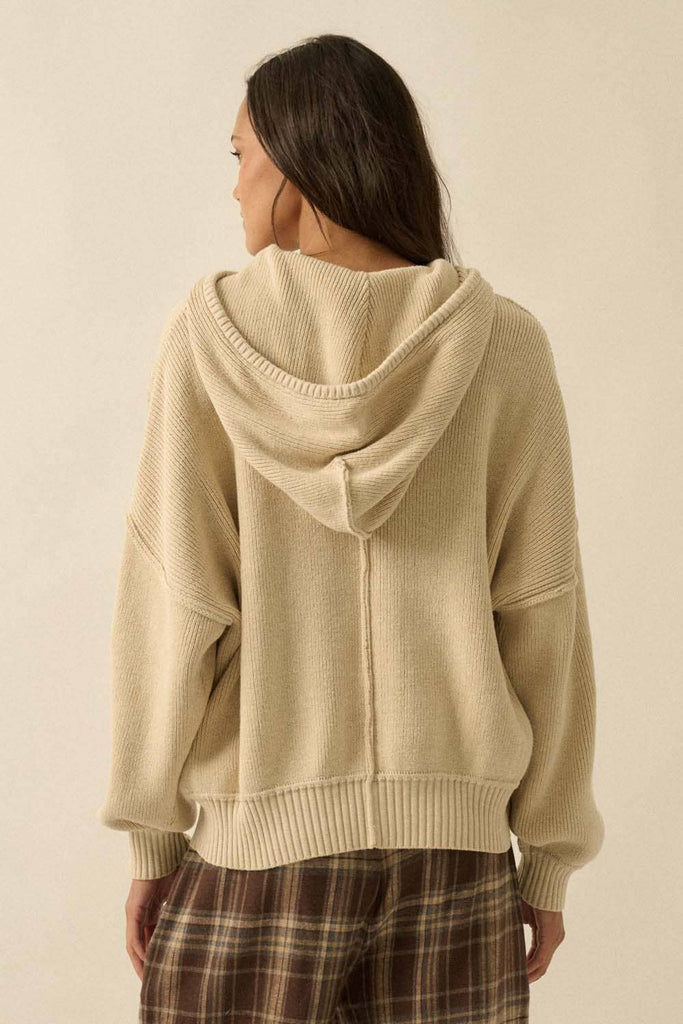 Woman wearing a beige hoodie with a neutral background