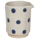 Ceramic cup with blue polka dots on a white background