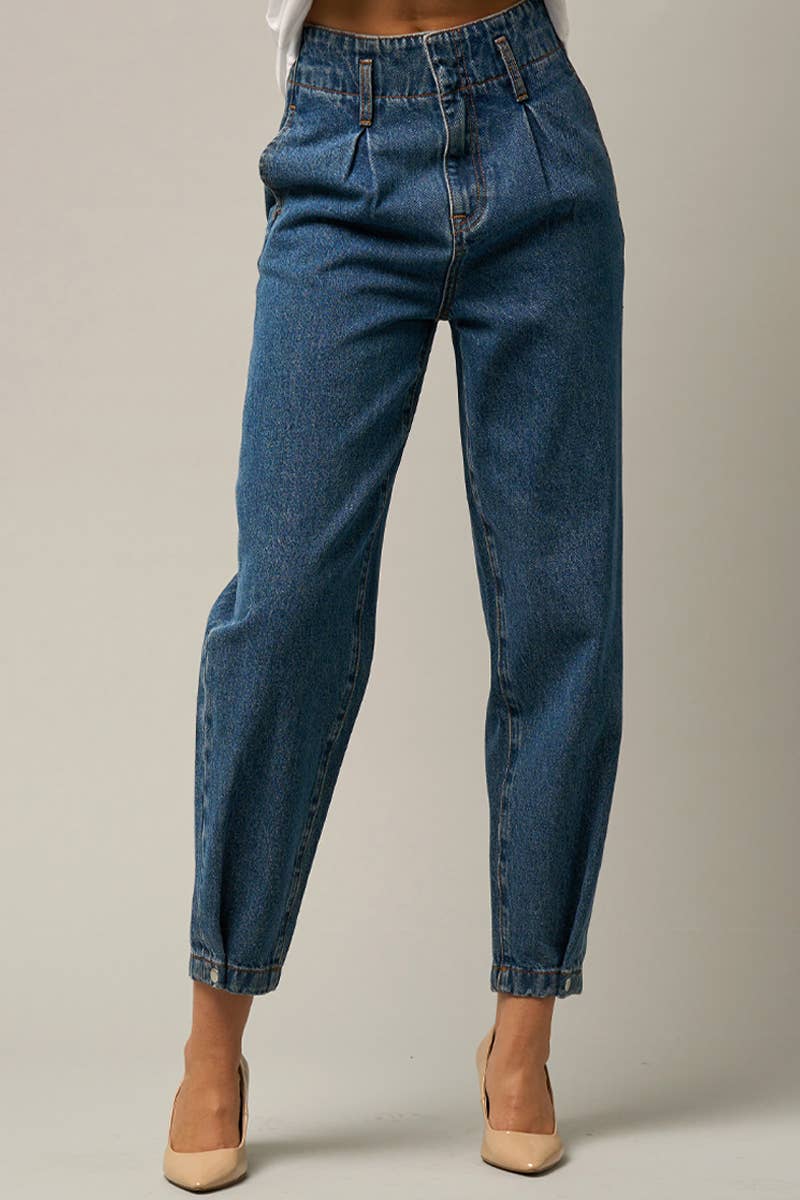  Model wearing high-waist balloon jeans with a relaxed silhouette and slightly tapered legs, paired with a casual graphic t-shirt and neutral heels.