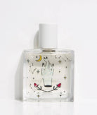 Maison Matine Avant l’Orage perfume bottle with celestial illustrations, placed among citrus fruits and sample vials on blue fabric