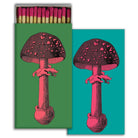 Matchbox featuring a pink and black mushroom illustration on green and teal backgrounds.