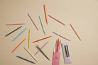 Colorful pens and pencils spread out on a beige background