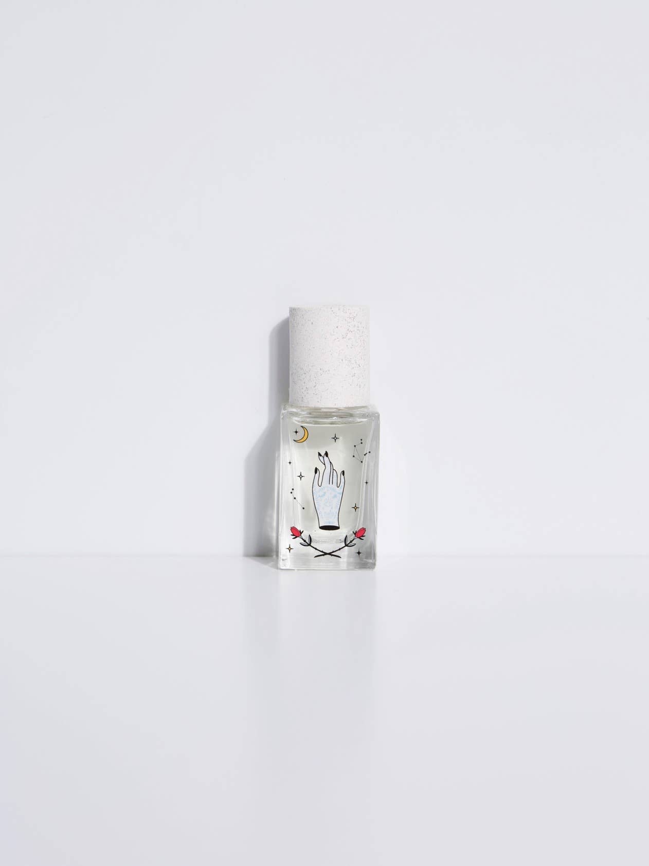 Maison Matine Avant l’Orage perfume bottle with celestial illustrations, placed among citrus fruits and sample vials on blue fabric