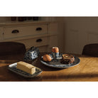 Butter dish, eggs, and a cake on a wooden table with a neutral background