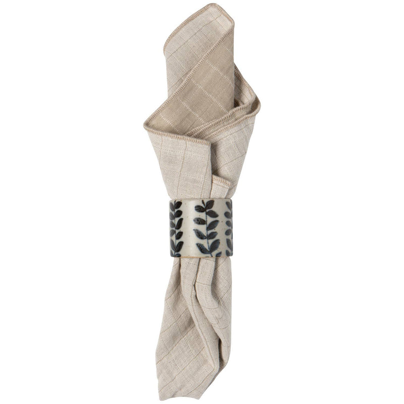 Folded beige napkin with a decorative metal clip on a white background