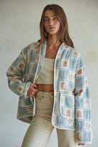 Quilted cotton jacket with desert-themed motifs and soft blue, cream, and terracotta tones