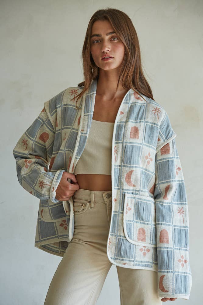 Quilted cotton jacket with desert-themed motifs and soft blue, cream, and terracotta tones