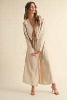Woman wearing a beige tie-front long sleeve top and matching wrap maxi skirt, styled as a coordinated skirt set.