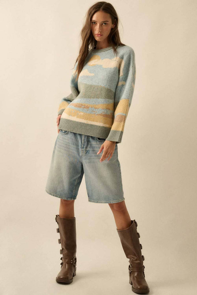 Woman wearing a striped sweater, denim shorts, and brown boots on a beige background