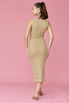 Woman wearing a beige sleeveless crochet top and midi skirt set.