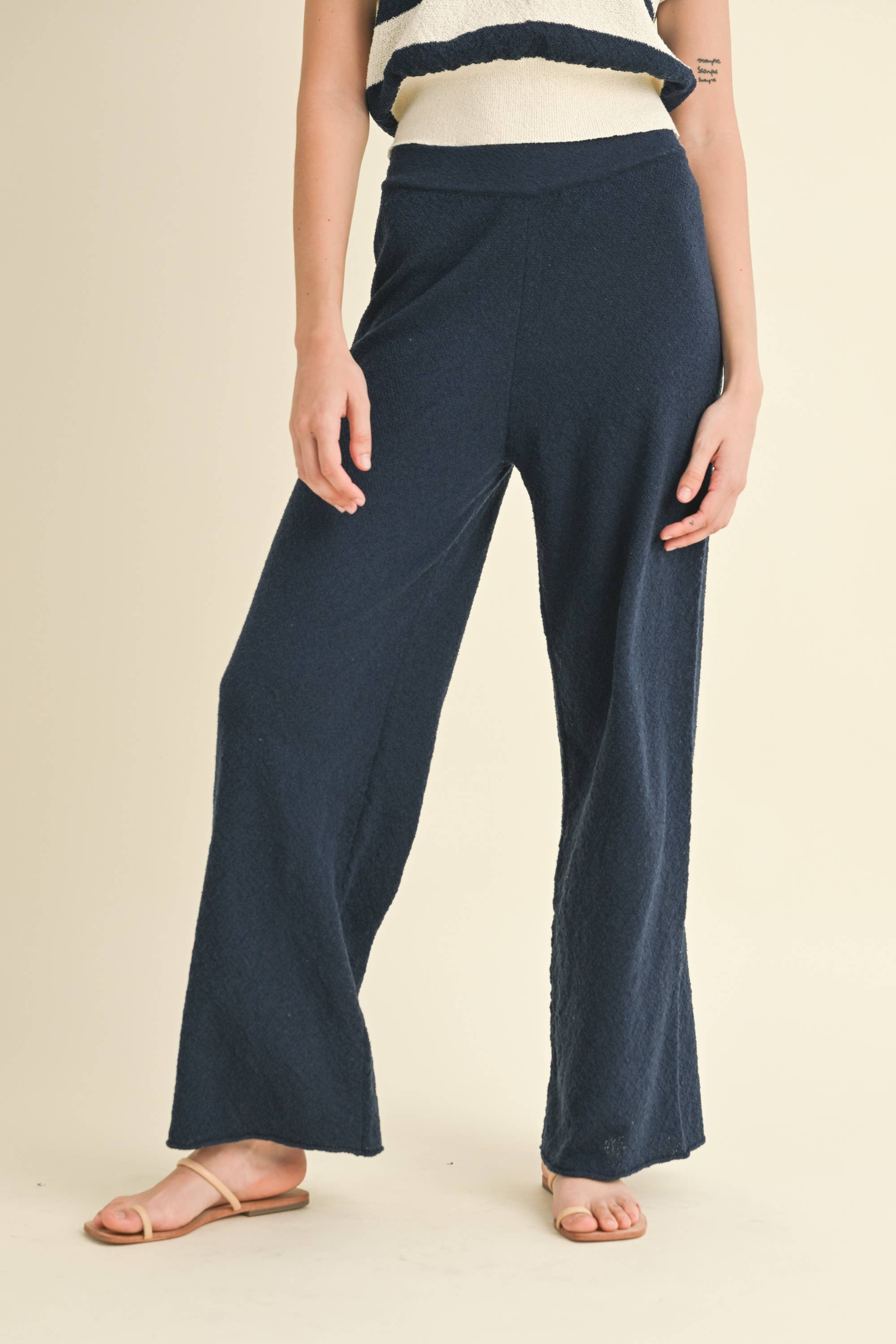 Model wearing navy blue knit wide-leg pants with a relaxed fit and soft texture.