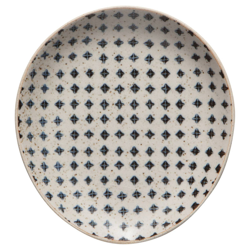 Ceramic spoon rest with a blue and black geometric pattern on a speckled cream background.
