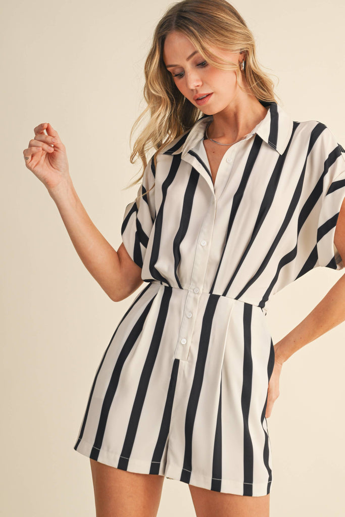 Black and white vertical striped romper with short sleeves, button-up front, and back waist tie