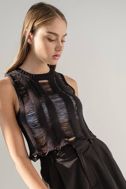 Woman wearing a black round neck sleeveless ladder knit crop top.