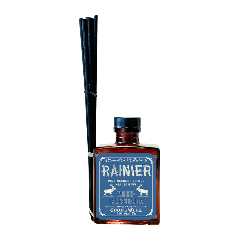 Rainier reed diffuser with amber glass bottle and black reeds by Good & Well Supply Co., featuring pine, citrus, and fir scents.