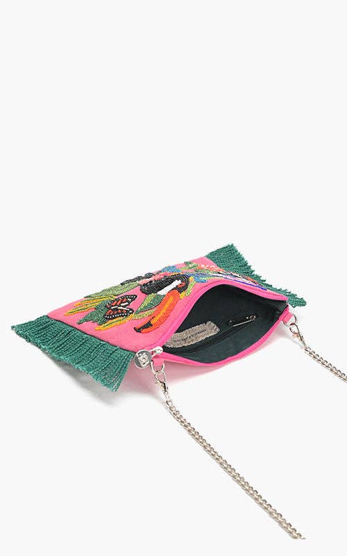 Pink beaded clutch with toucan, butterfly, and tropical floral embroidery, green fringe sides, and silver chain strap.