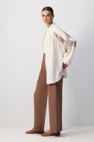 Back view of a woman wearing a cream embroidered kimono with sequin detailing and wide sleeves.