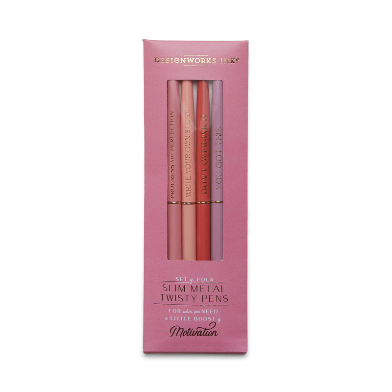 A set of four slim metal twist pens with gold foil phrases on each, packaged in a pink box.