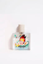 Maison Matine Lost in Translation perfume bottle with bold illustrated design, placed on vibrant yellow textured surface.