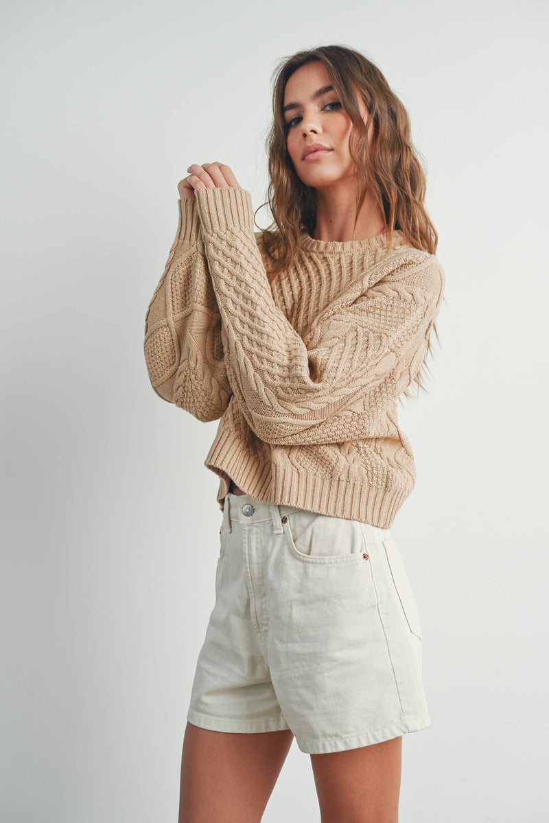 Sandridge Cable Knit Sweater with intricate cable detailing, relaxed fit, and warm beige hue, perfect for layering in any season.