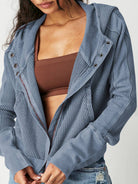 Woman wearing a Sahara Sky Hooded Jacket with a zip-up front, textured waffle knit, and button detailing in blue and brown tones.