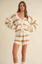 Woman wearing a cream and camel striped knit set with button cardigan and drawstring shorts.