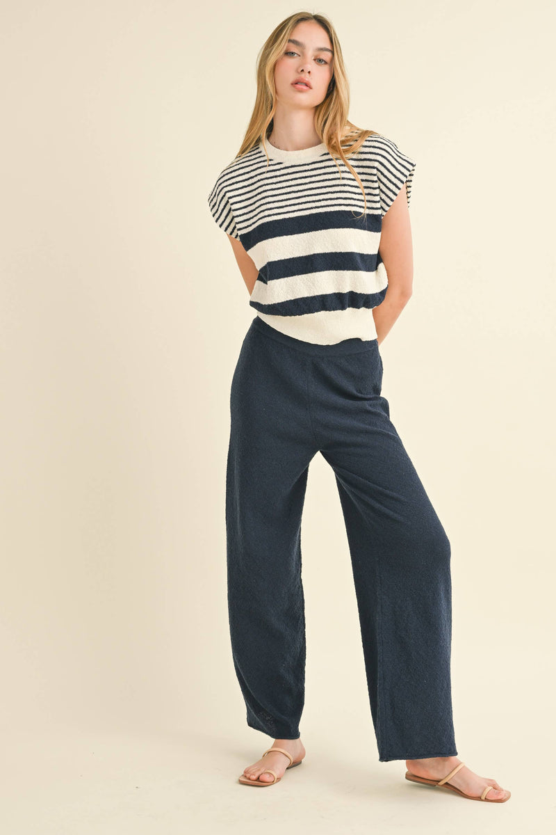 Model wearing navy blue knit wide-leg pants with a relaxed fit and soft texture.