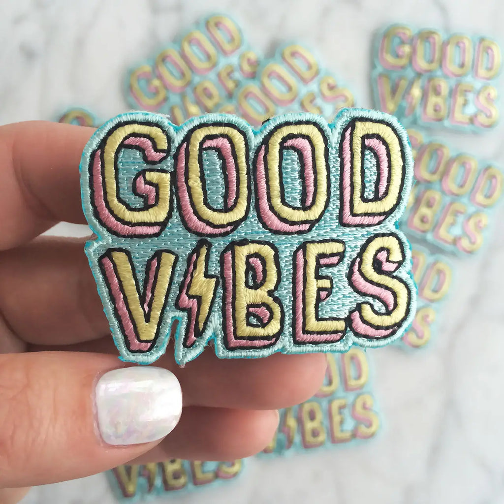 Colorful embroidered patch with the message "Good Vibes" in bold letters.