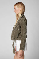 Woman wearing a green jacket on a gray background