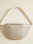 Studded handbag with beige strap on a light beige background