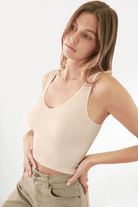 Fashion-forward woman wearing FORMA's Victoria V Neck Ribbed Crop Top, showcasing its flattering design and snug fit.