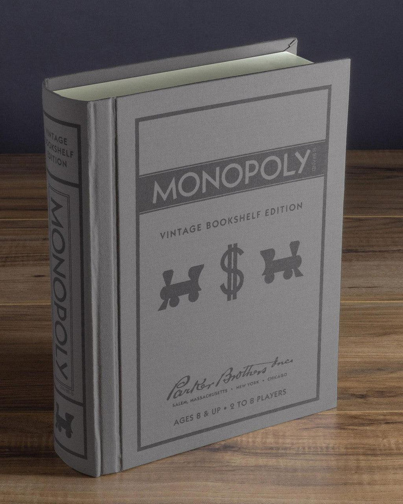 Monopoly Vintage Bookshelf Edition with a book-like packaging, game pieces, wooden houses and hotels, and a foldable game board.