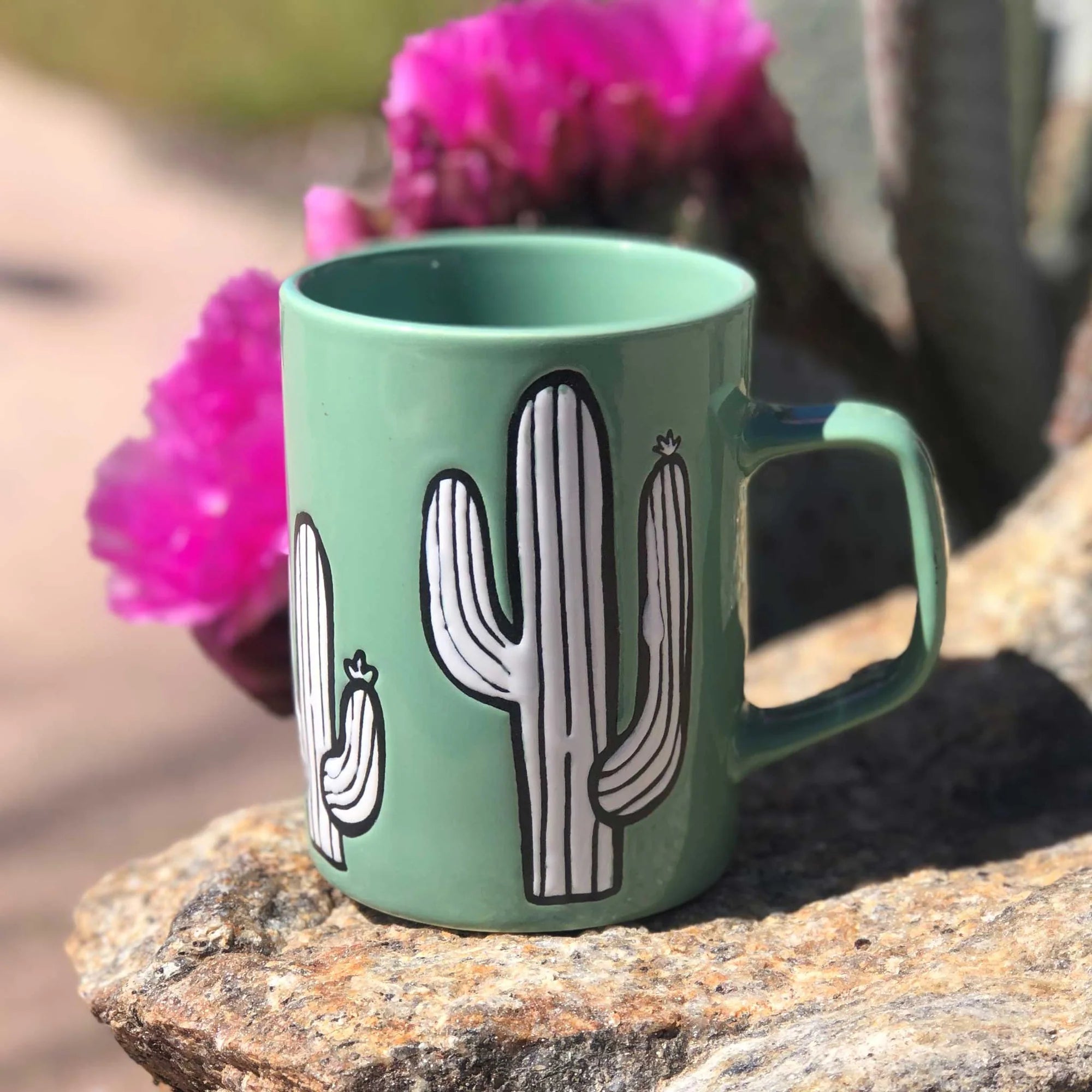 A ceramic mug with a distinctive cactus-inspired design, placed on a kitchen table.