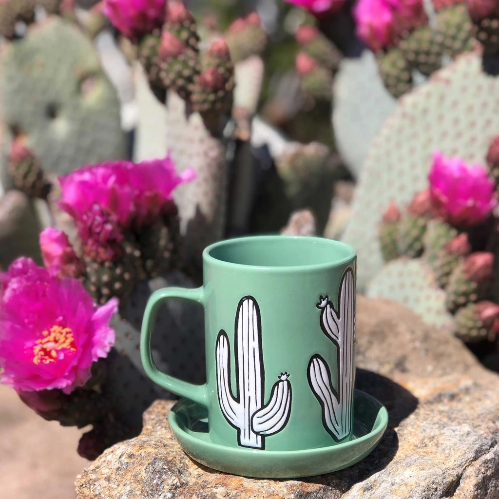 A ceramic mug with a distinctive cactus-inspired design, placed on a kitchen table.
