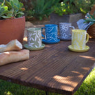 A Ceramic Olive Branch Mug with a delicate olive branch design, placed on a soft-hued surface.