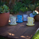 A Ceramic Sage Leaf Mug with a detailed sage leaf pattern, placed on a neutral-toned surface.