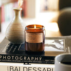 Patchouli Sweetgrass Soy Candle in a simple glass jar, with a label showcasing the rich, earthy blend of patchouli and sweetgrass.
