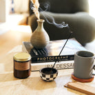 Patchouli Sweetgrass Soy Candle in a simple glass jar, with a label showcasing the rich, earthy blend of patchouli and sweetgrass.