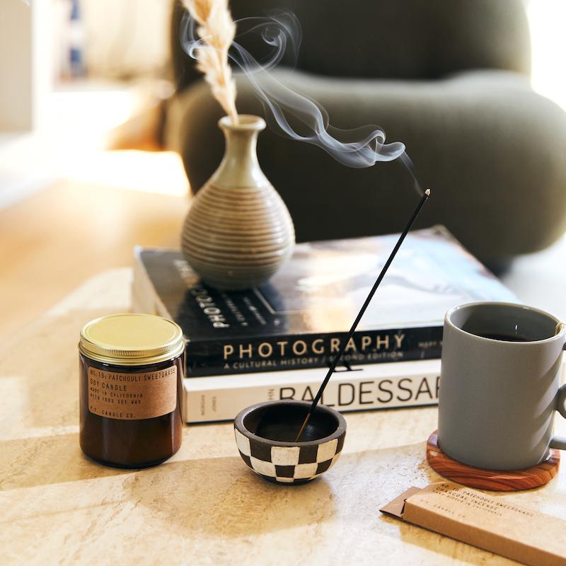 Patchouli Sweetgrass Soy Candle in a simple glass jar, with a label showcasing the rich, earthy blend of patchouli and sweetgrass.