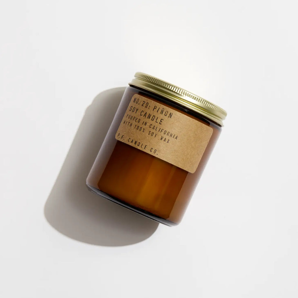 Piñon Soy Candle in recyclable packaging, releasing a warm, earthy piñon pine scent.
