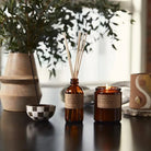 Piñon Soy Candle in recyclable packaging, releasing a warm, earthy piñon pine scent.